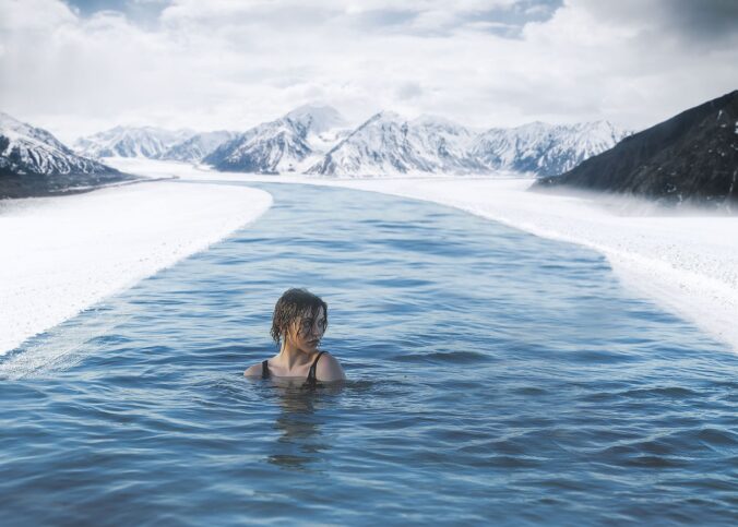 Une femme se baignant dans une eau glacée dans la neige.